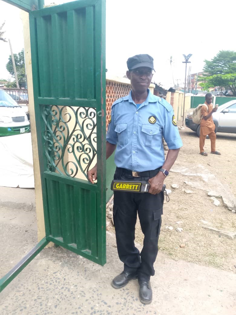Security Guard at Gate with Metal Detector